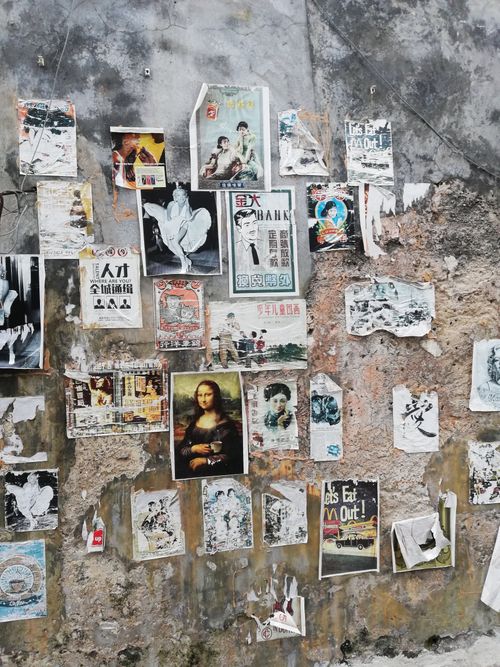Free A textured wall covered with vintage posters in Georgetown, Penang. Stock Photo