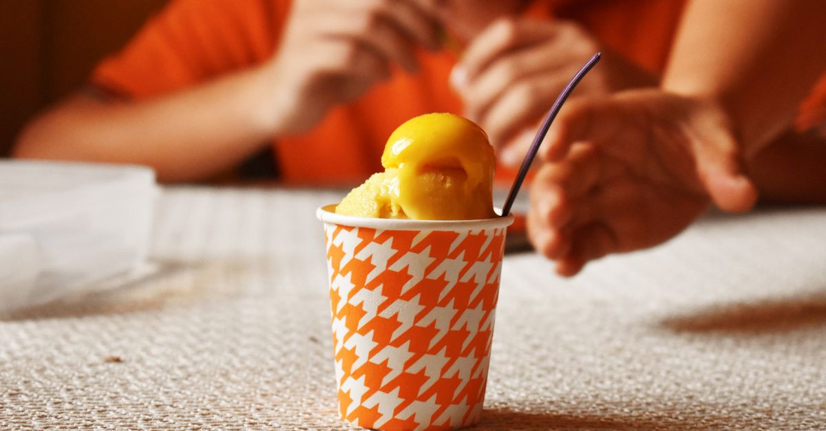 melted soft serve ice cream in a tilted cup with a spoon