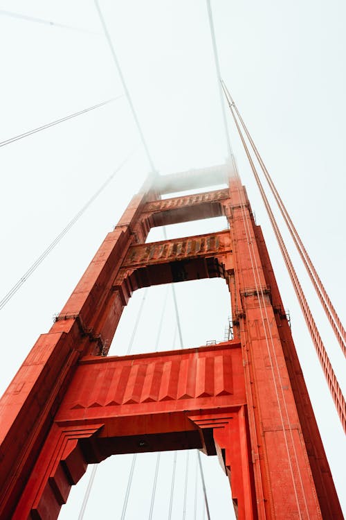 From below of famous red Golden Gate Bridge hidden under foggy sky in San Francisco