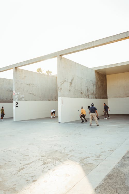 Anonymous athletes playing handball in outdoor courts in sunlight