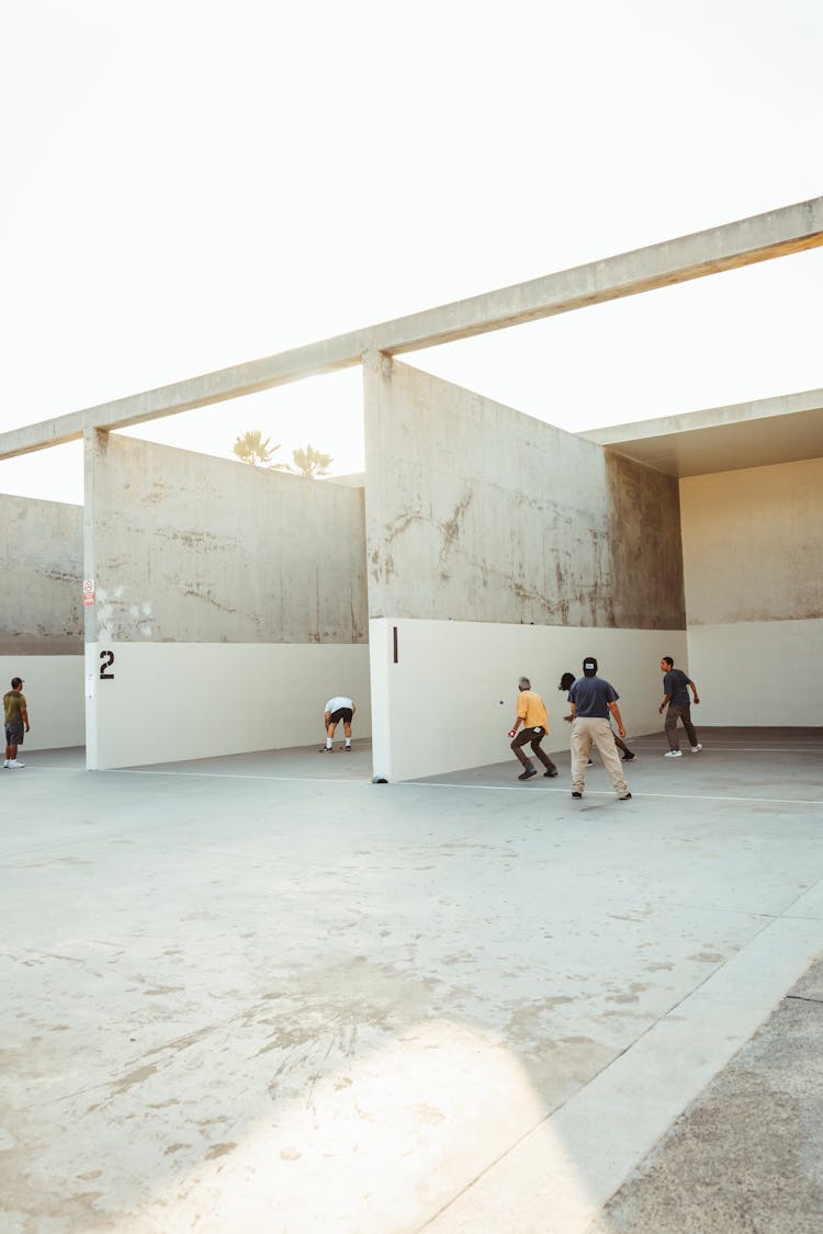 Anonymous Athletes Playing Handball In Outdoor Courts In Sunlight