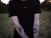 Crop tattooed man chilling in nature at sundown