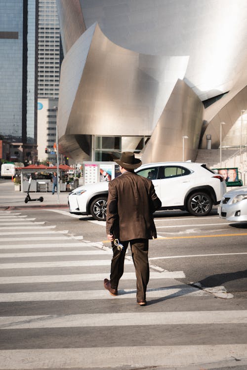 Anonymous stylish businessman crossing road in downtown