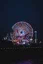 Illuminated Ferris wheel in amusement park at night
