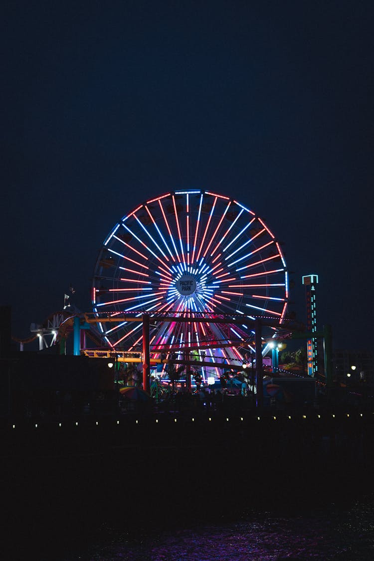 Illuminated Ferris Wheel In Amusement Park At Night