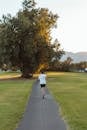 Unrecognizable woman jogging along footpath in park