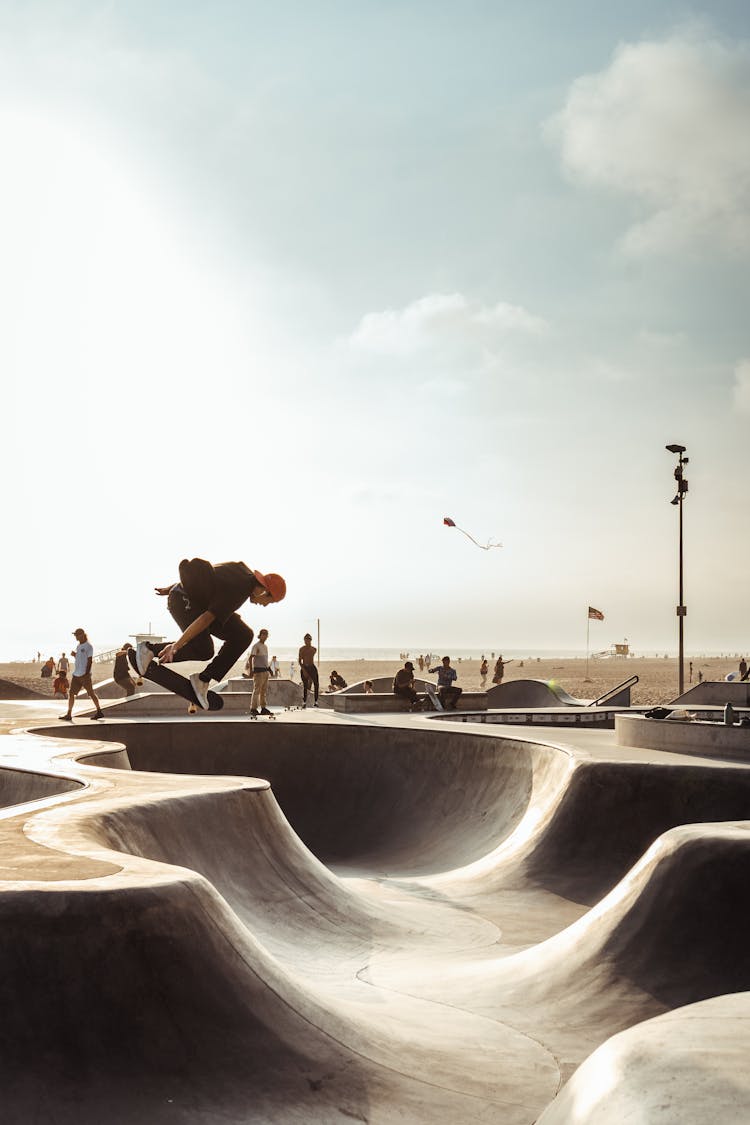 Anonymous Guy Riding Skateboard On Ramp On Sandy Beach