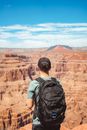 Anonymous male backpacker recreating in rocky canyon on sunny day