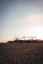 Amusement park on sandy beach at sundown