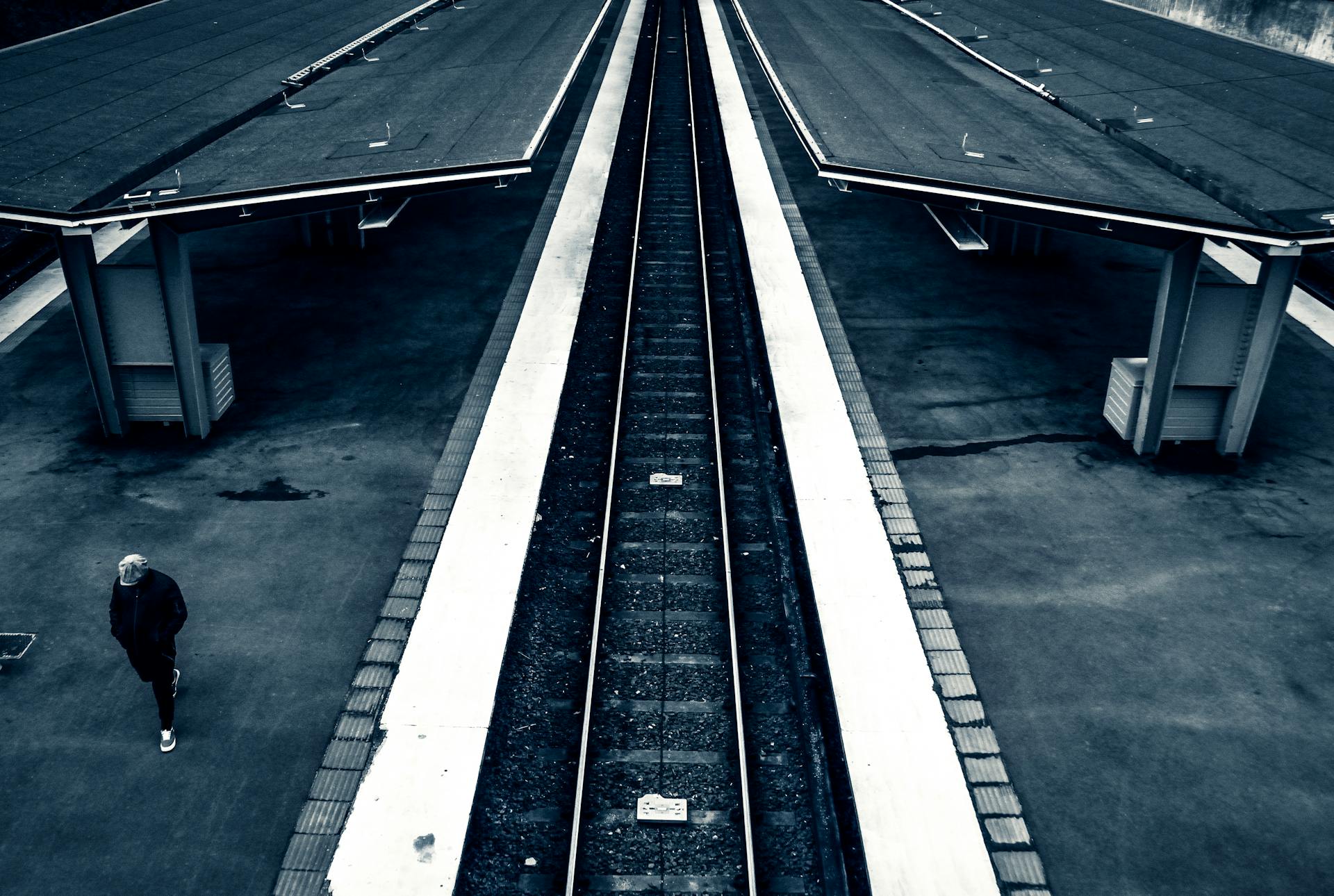 Monochromatic aerial view of a Stockholm train station platform showcasing symmetry and urban design.