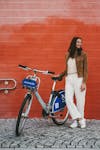 Free Woman in Brown Jacket Standing Beside Bicycle Stock Photo