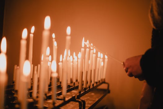 Multiple candles lit during a solemn vigil in a Maastricht church, evoking a serene and spiritual atmosphere.