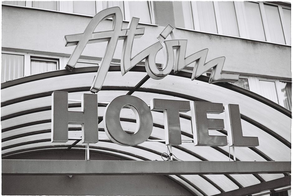 Black and white photo of the Atom Hotel entrance sign, showcasing vintage design.