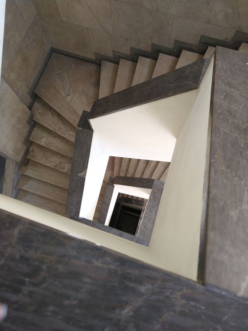 Free Top view of a geometrical spiral staircase captured in a modern architectural setting. Stock Photo