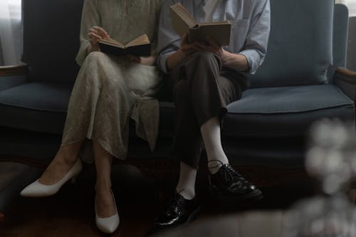 Free People Sitting on a Couch Reading Books Together  Stock Photo
