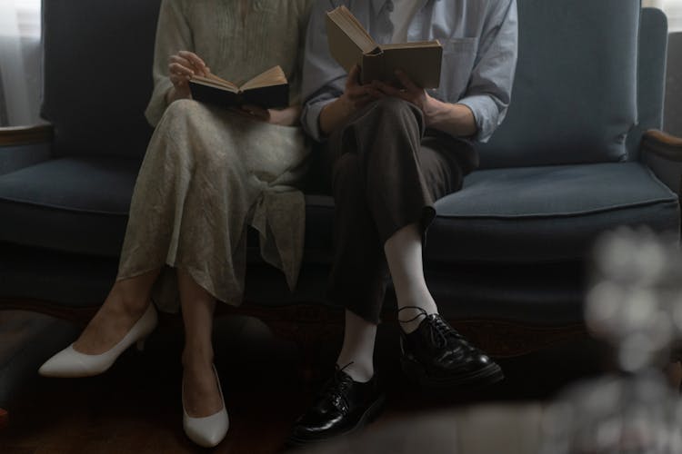 People Sitting On A Couch Reading Books Together 