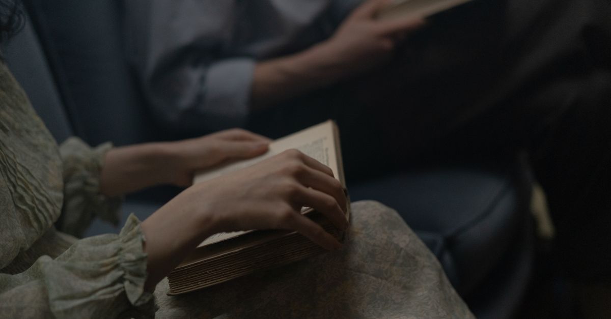 Intimate scene of adults reading books together indoors, capturing the essence of relaxation.