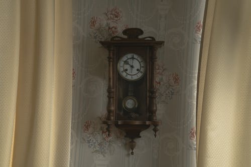 Wooden Pendulum Clock Hanging Near the Curtains