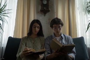 Man and Woman Sitting on a Blue Couch While Reading Books 