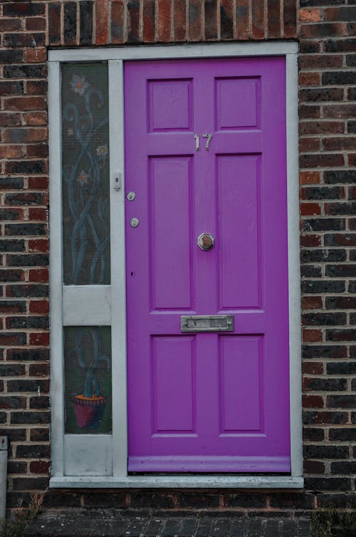 Purple Wooden Door on Brown Brick Wall