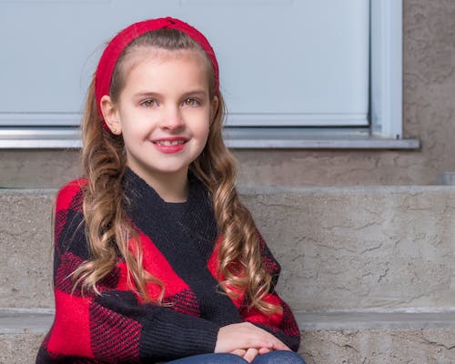 Free Girl Wearing a Red Headband Sitting on the Steps Stock Photo