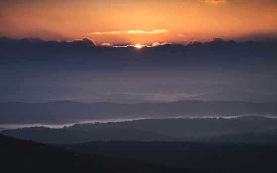 Breathtaking view of a sunset over rolling mountain landscapes in Podkarpackie, Poland.