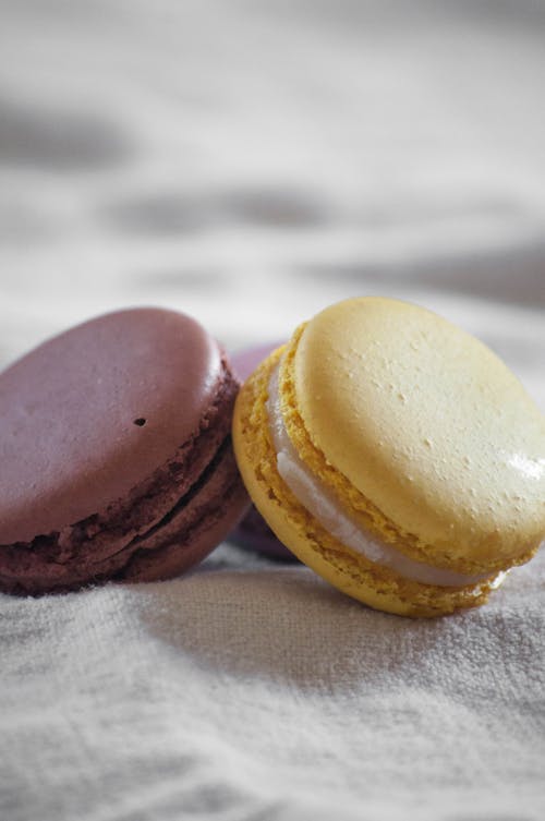 Brown and Yellow French Macarons on White Textile