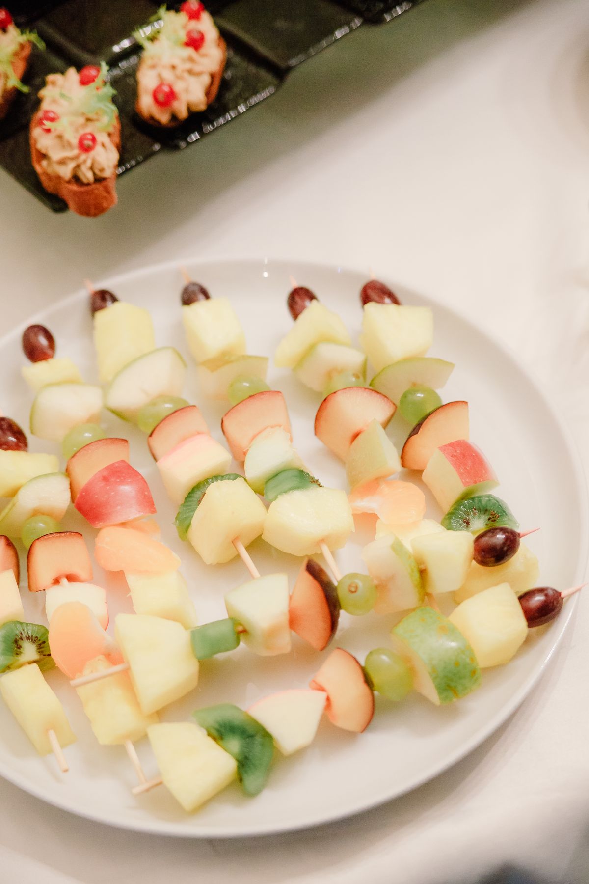 Colorful fruit skewers with apples kiwis and grapes