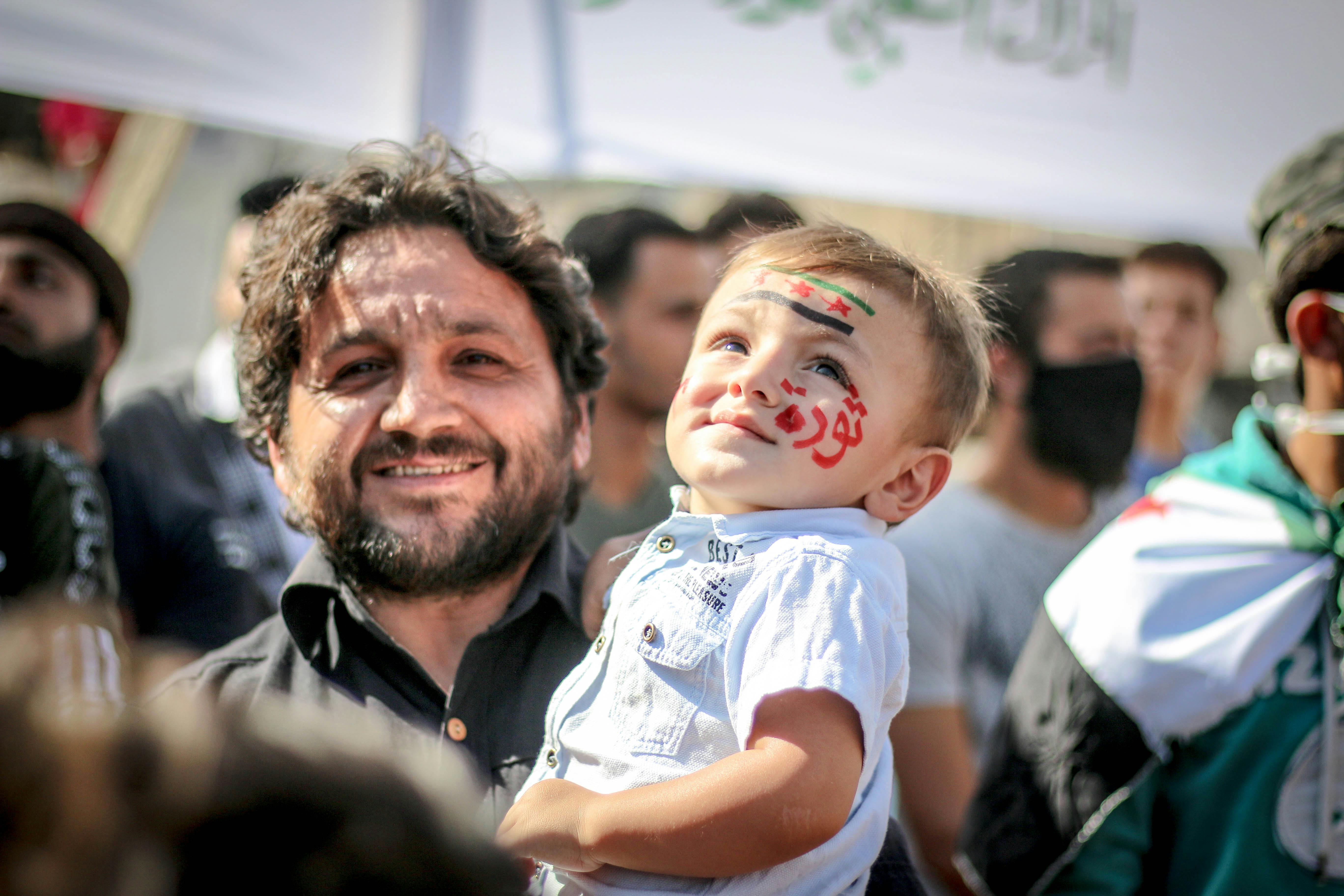 ethnic father and son with painted face at demonstration