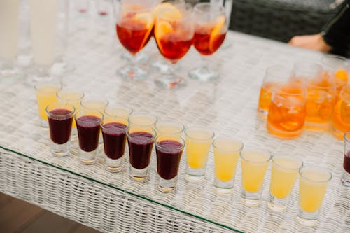 Free Shot Glasses With Alcoholic Drinks on Wicker Table Stock Photo