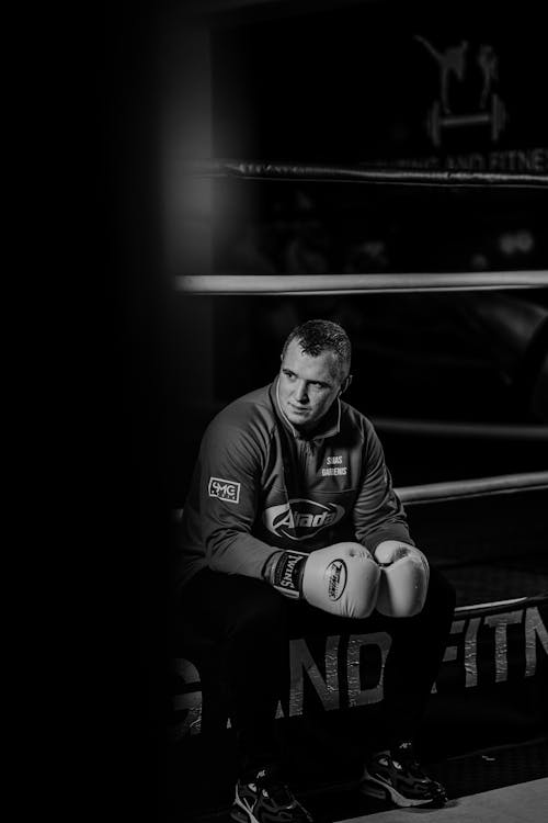Serious boxer resting in ring of gym