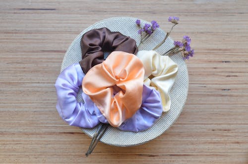 Multicolored hair bands with blossoming flowers in sunlight