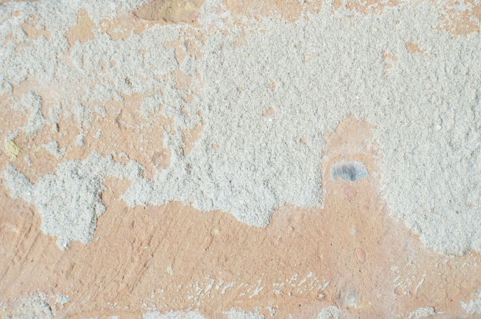 Top view of textured backdrop of old wall with solid structure and rugged beige and white surface in daylight