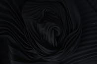 Textured backdrop of soft crumpled textile in darkness