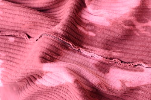 Free From above abstract background of pink knitted textile with inside seam on table Stock Photo