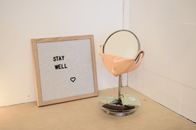 Face mask placed on table mirror near framed image