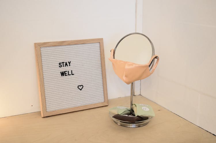 Face Mask Placed On Table Mirror Near Framed Image