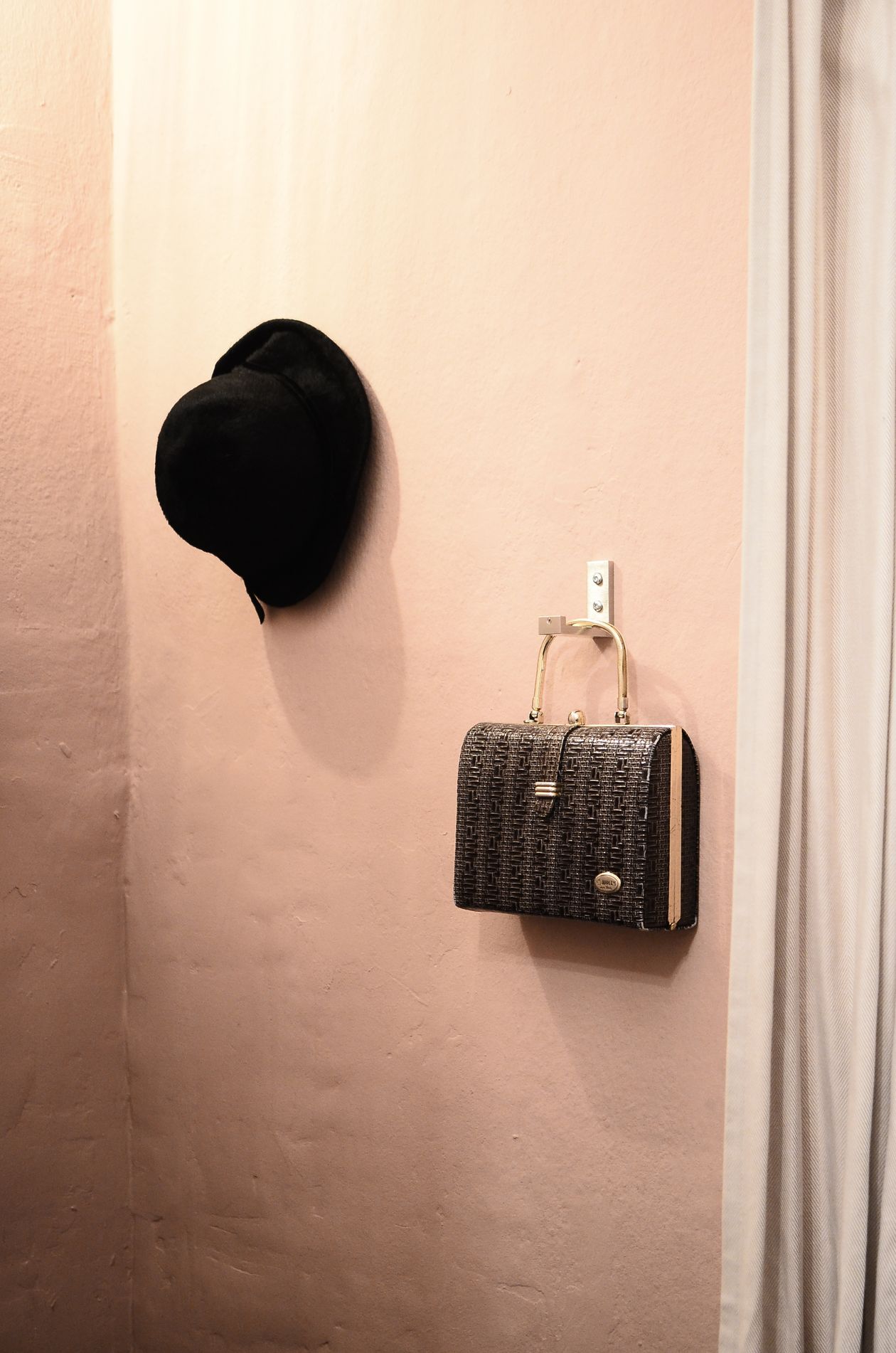 Hooks inside a wardrobe door holding bags and a dressing gown.