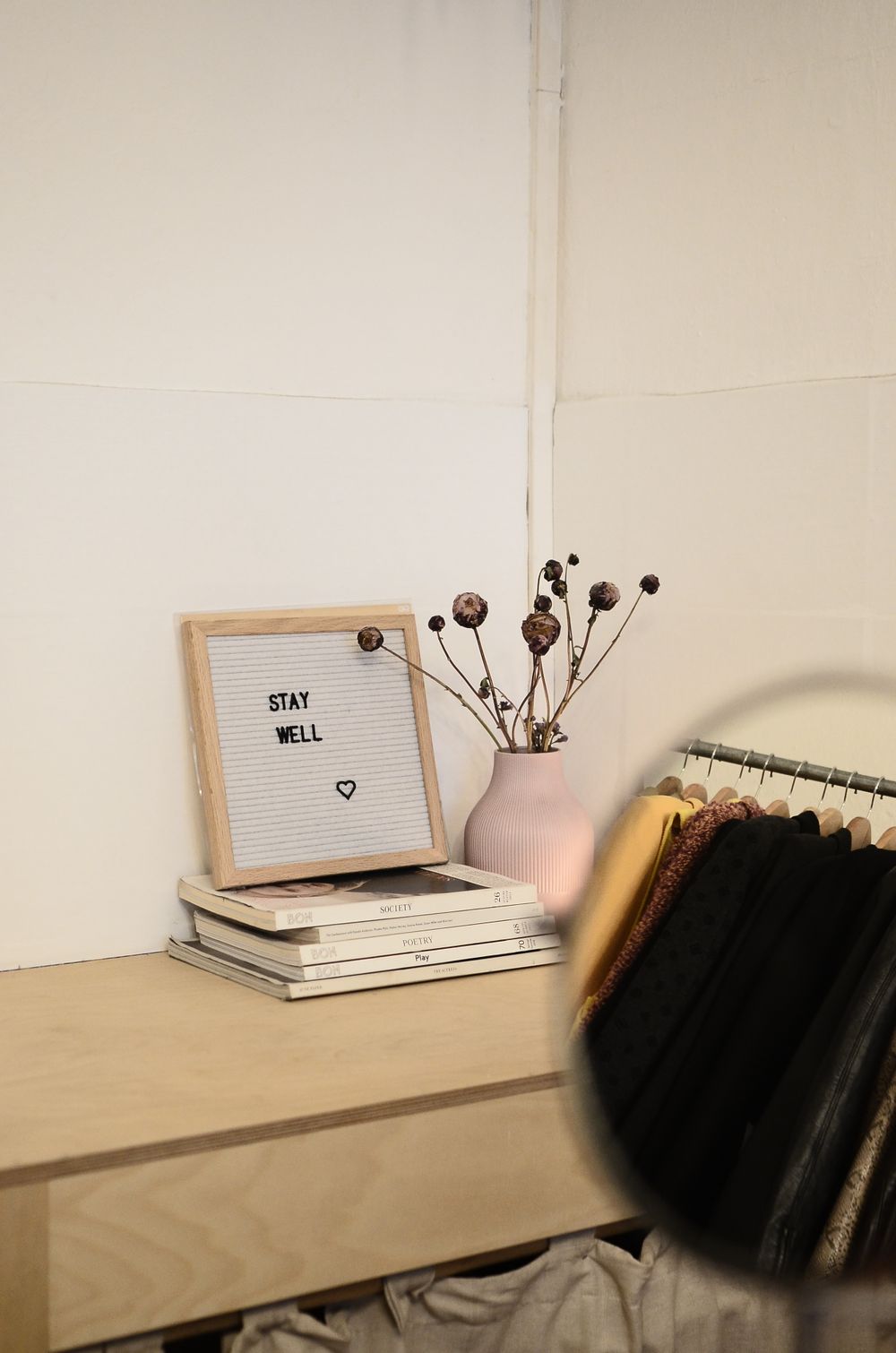 Framed print beside a vase of dried plants