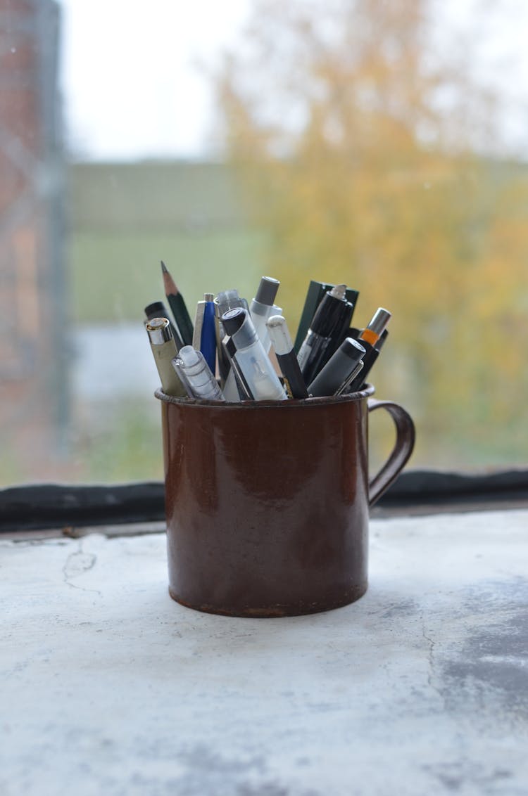 Cup With Pencils And Pens On Windowsill