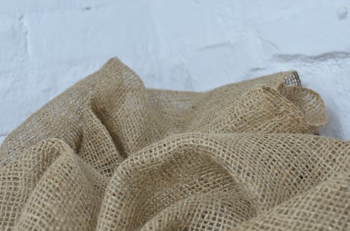 Crumpled sackcloth with thin fibers on white background