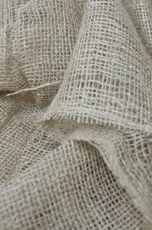 Top view closeup of background representing crumpled eco textile with thin fibers and rough texture