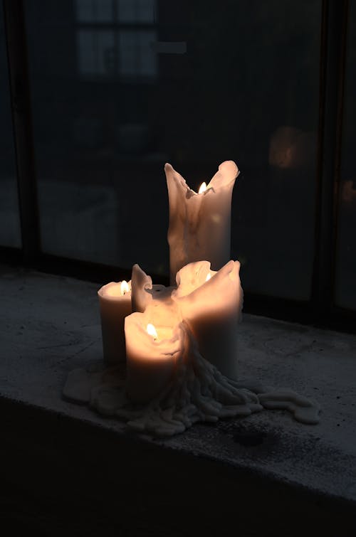 Free Burning candles with melted wax at night Stock Photo