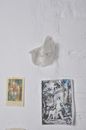 Postcard and paper with pictures on whitewashed wall