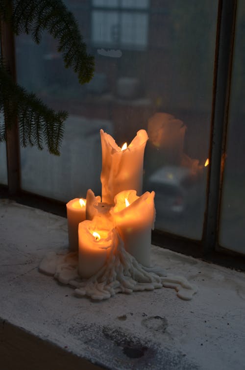 Shiny candles reflecting in window at home in twilight