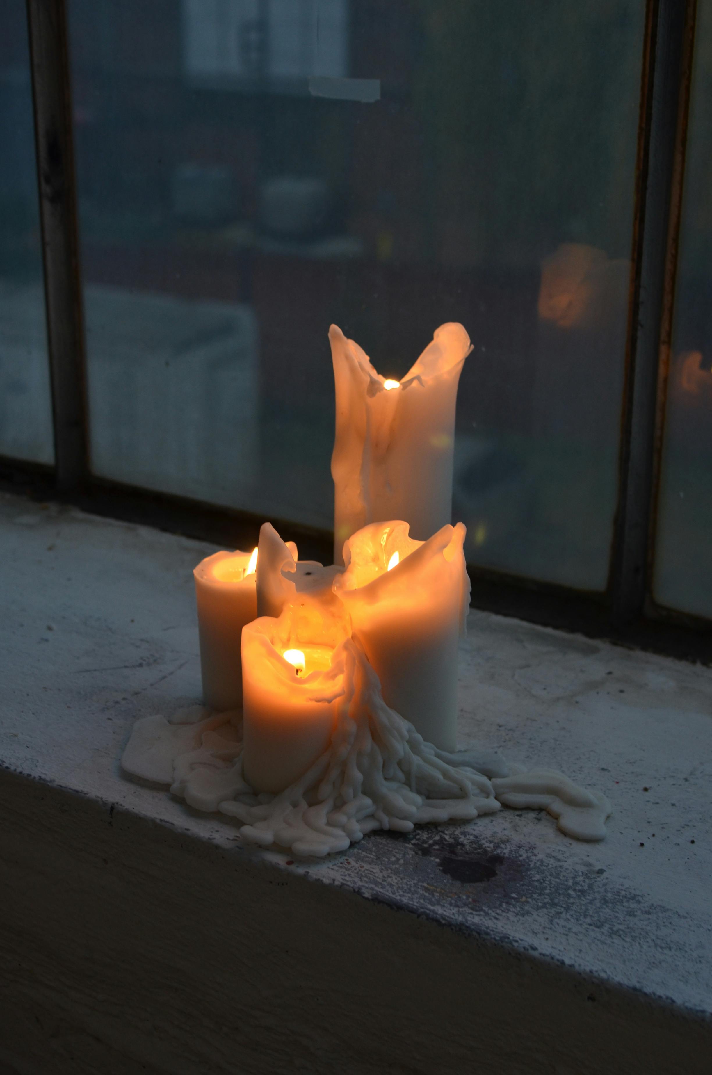 burning candles on windowsill at home in twilight