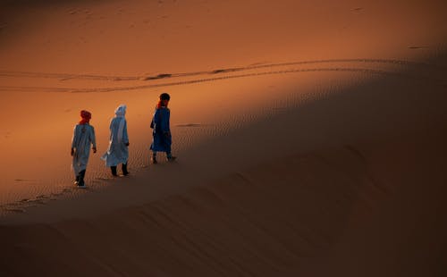 Group of People Walking on a Desert