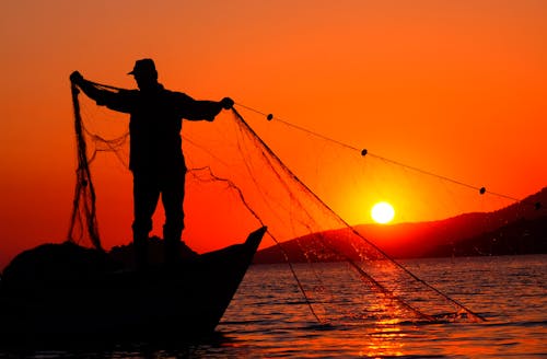Free Fotos de stock gratuitas de barco de pesca, cielos anaranjados, de pie Stock Photo
