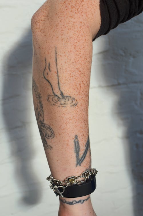 Crop person with different tattoos on arm