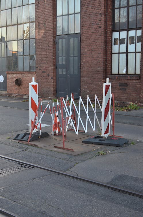 Free Restrictive fences prohibiting passage on road section next to tram tracks in city district Stock Photo